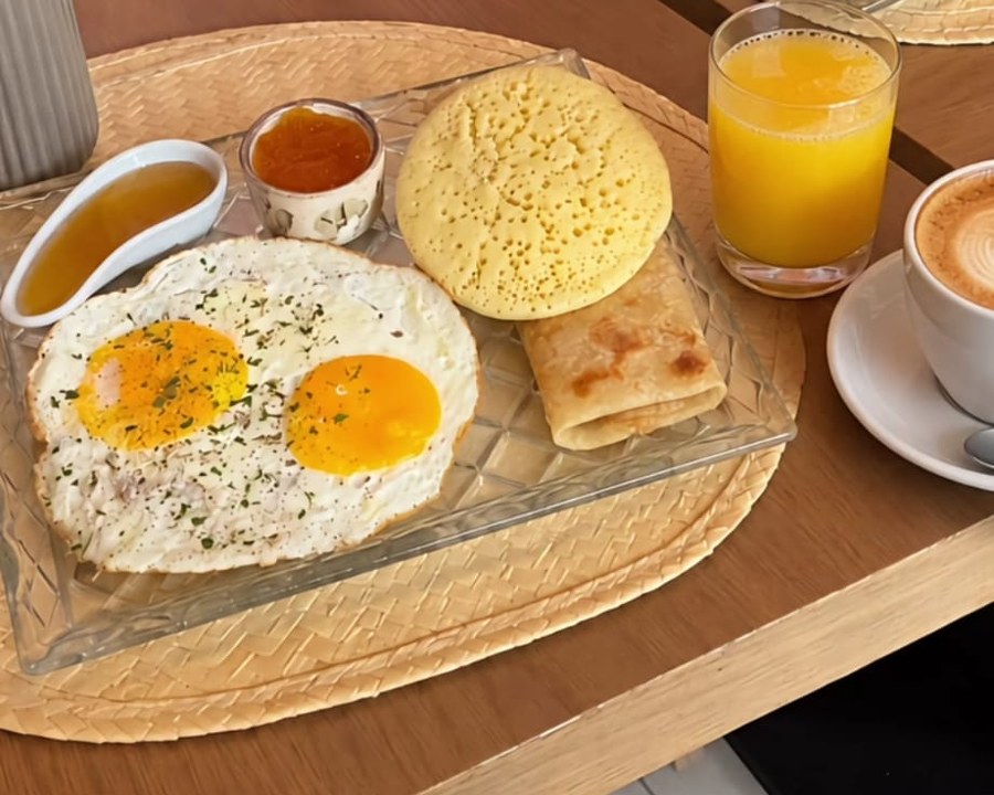 Petit-déjeuner marocain : œufs au plat, baghrir, msemen, jus d’orange et café