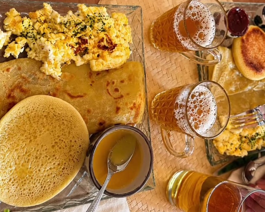 Plateau de petit-déjeuner marocain avec œufs brouillés, msemen et thé